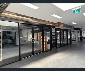 Modern commercial retail unit with glass storefronts and dark aluminium framing
